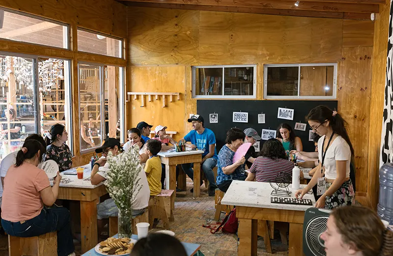 En ambas ediciones, nuestro taller albergó un espacio destinado al ocio con cojines gigantes, cafetería solidaria y juegos sencillos en papel, complementados con actividades como campeonatos de bingo y bachillerato.